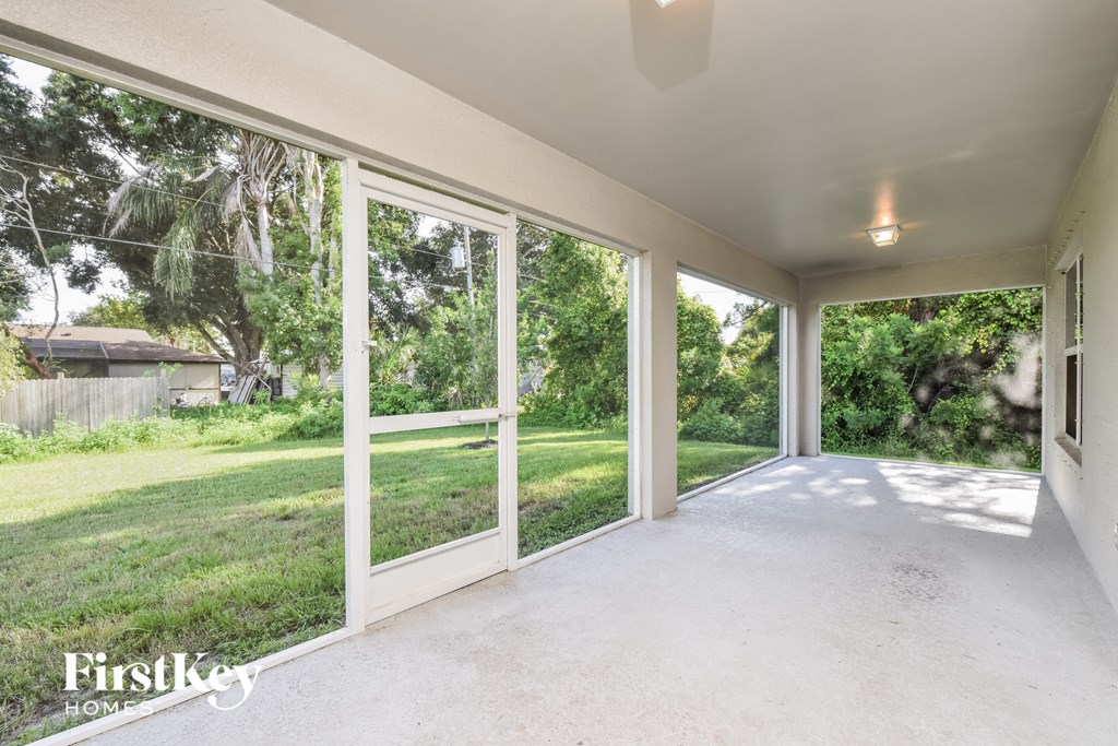 A sunny day in a spacious room with a view of a green backyard.
