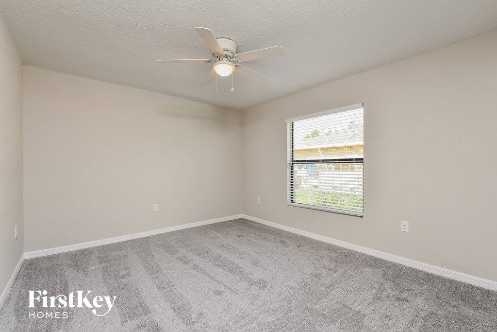 a bedroom with a ceiling fan and a window