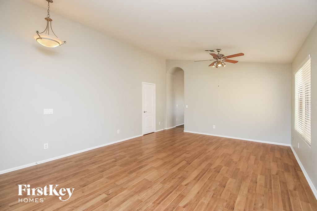 a living room with a hardwood floor and a ceiling fan