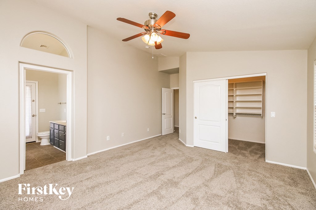 a living room with a ceiling fan and a closet