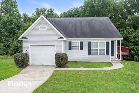 A house with a grey roof and a white garage door.