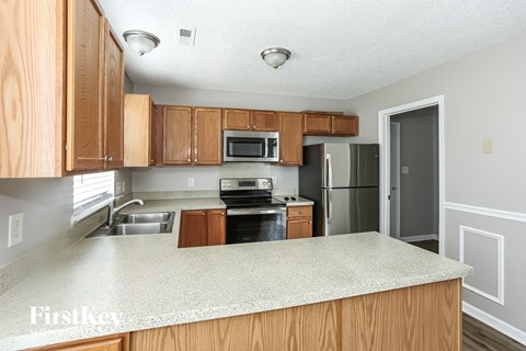 A kitchen with wooden cabinets and a granite countertop.
