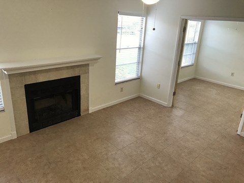 a living room with a fireplace and a tiled floor