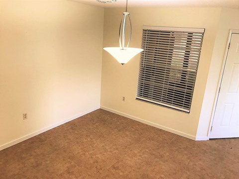 a empty living room with a window and a lamp