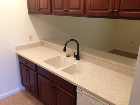 a kitchen counter with a sink and wooden cabinets