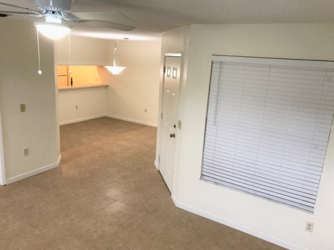 an empty room with a window and a ceiling fan