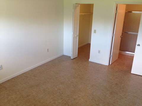 an empty living room with a closet and an open door