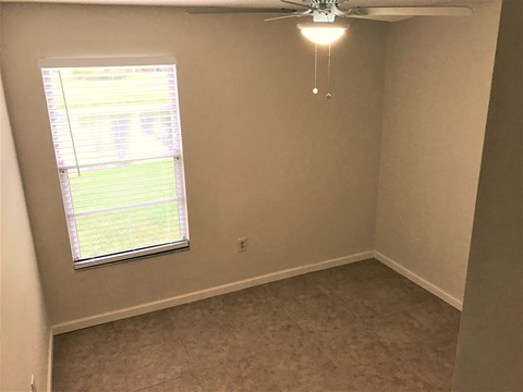 a bedroom with a ceiling fan and a window