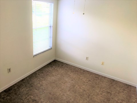 a empty room with a window and vinyl flooring
