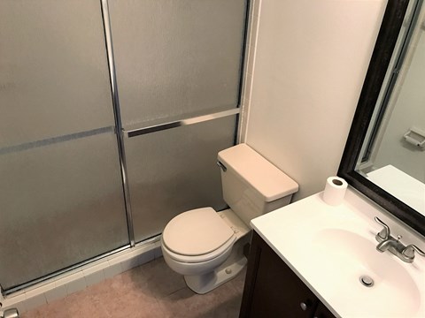 a bathroom with a shower and a toilet and a sink