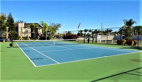 a blue and green tennis court with a flag