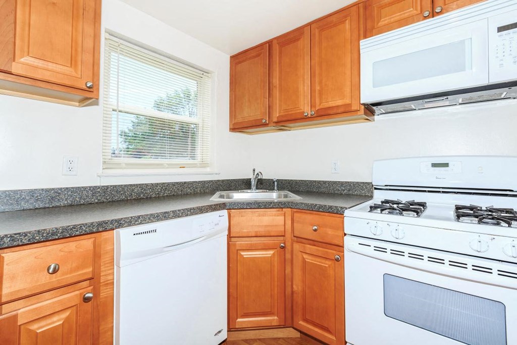 a kitchen with white appliances and wooden cabinets