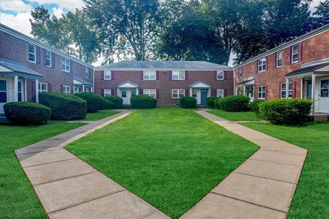a yard in front of a brick apartment building