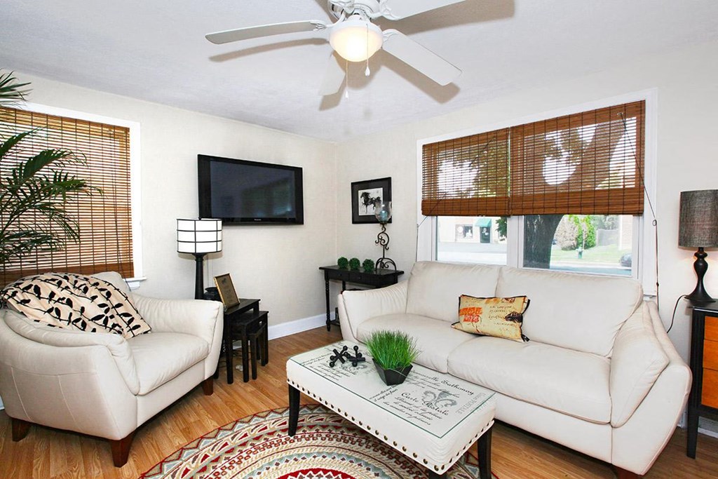 a living room with a white couch and a ceiling fan