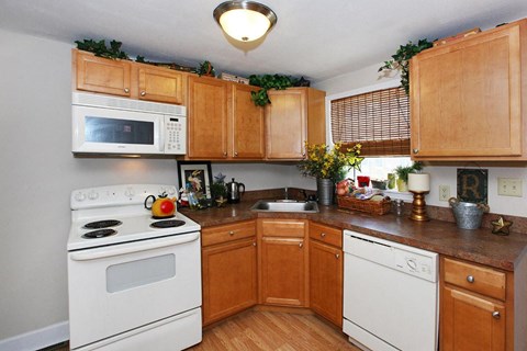 a kitchen with white appliances and wooden cabinets