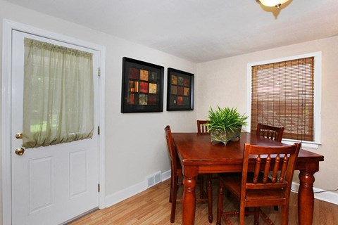 a dining room with a wooden table and chairs