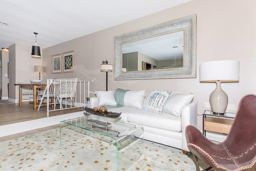 a living room with a white couch and a glass table