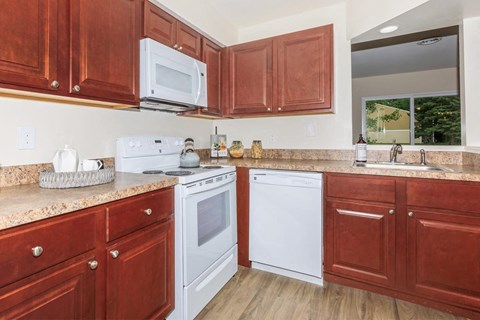 a kitchen with white appliances and wooden cabinets
