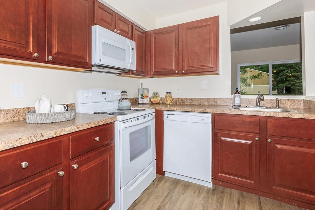 a kitchen with white appliances and wooden cabinets