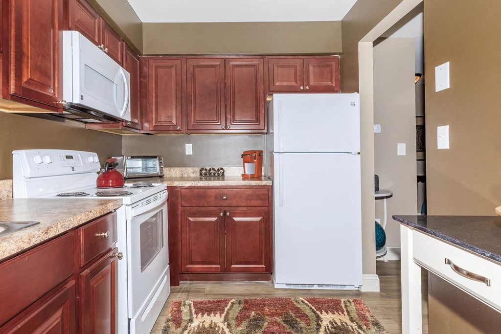 a kitchen with white appliances and brown cabinets