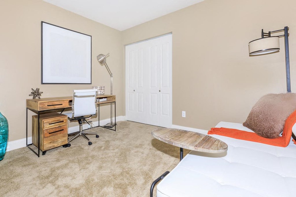 a bedroom with a bed and a desk with a chair