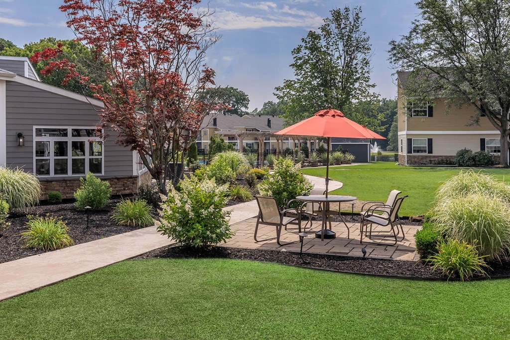 a patio with a table and chairs in a yard