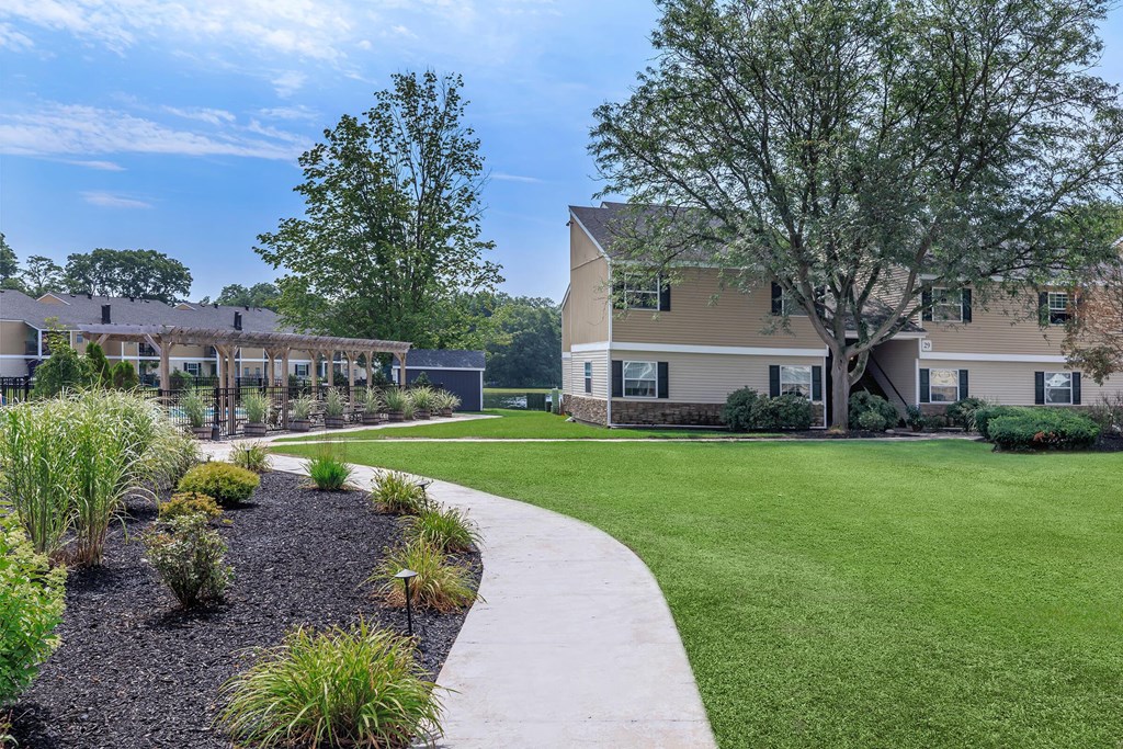 a yard with a sidewalk in front of some houses