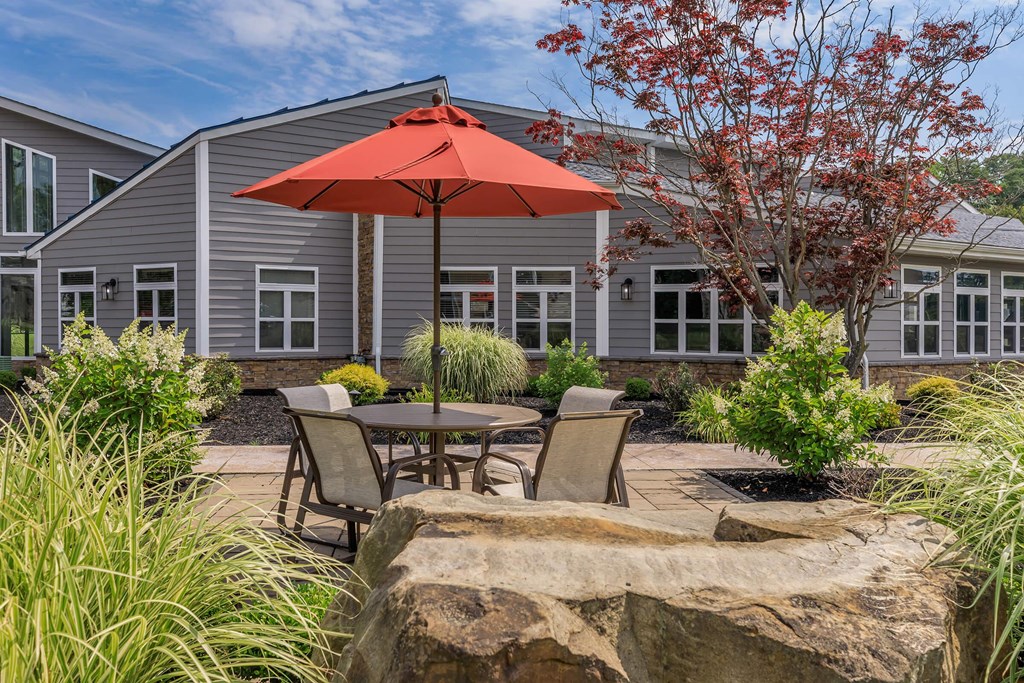 a patio with an umbrella in front of a house