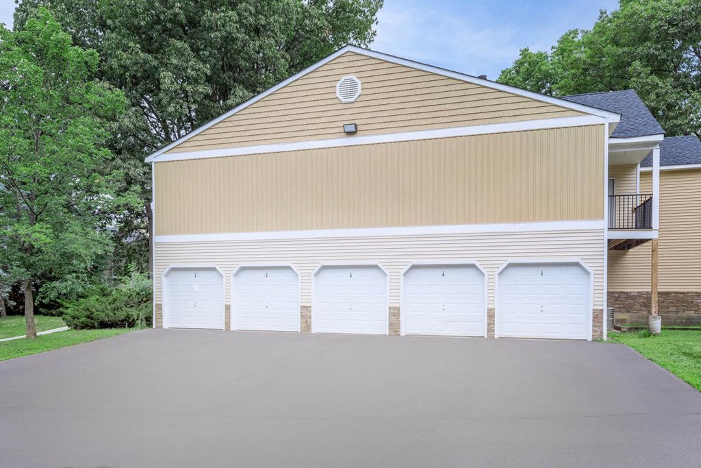 a garage with white doors on the side of a house