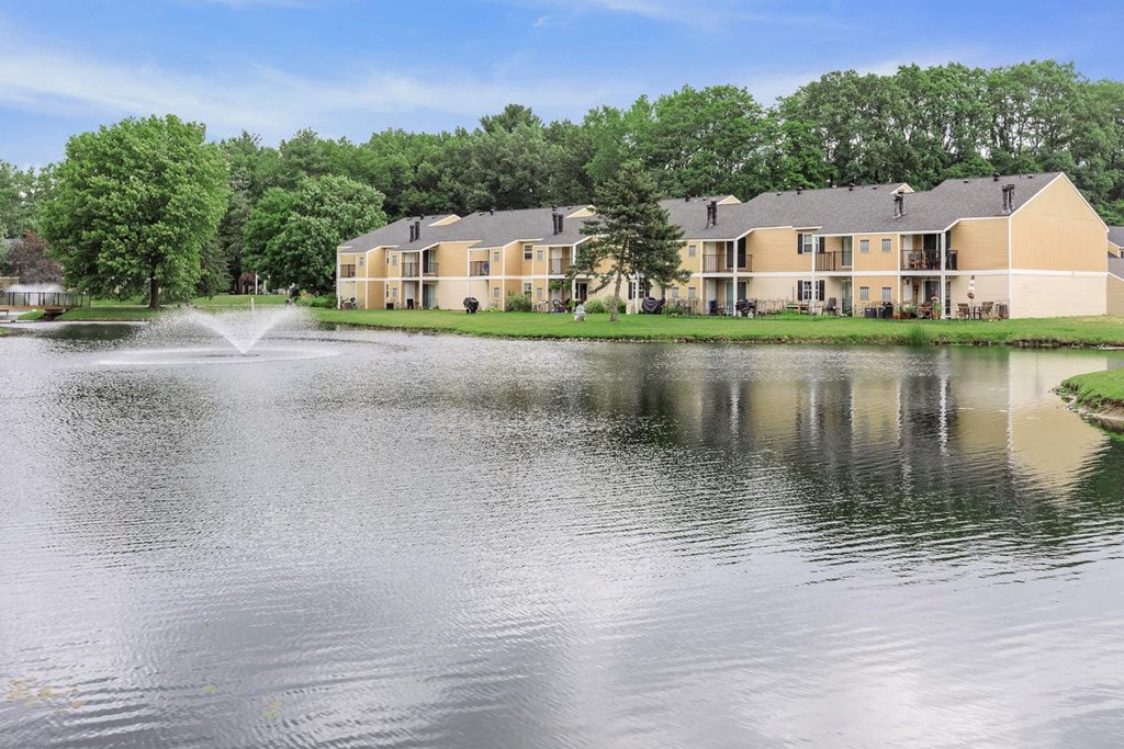 a large lake with a fountain in front of a building