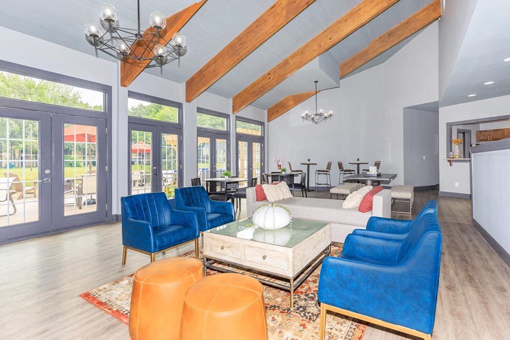 a living room with blue chairs and a table     and a large