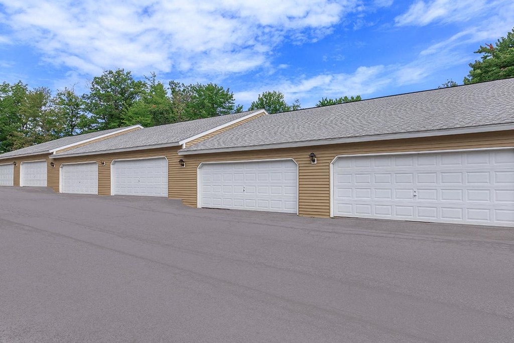 a row of white garage doors in front of a building