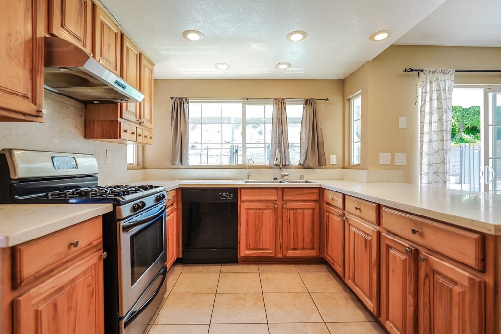 a kitchen with wooden cabinets and a stove and a sink