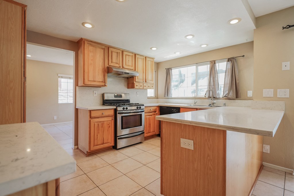 a kitchen with wooden cabinets and a white counter top