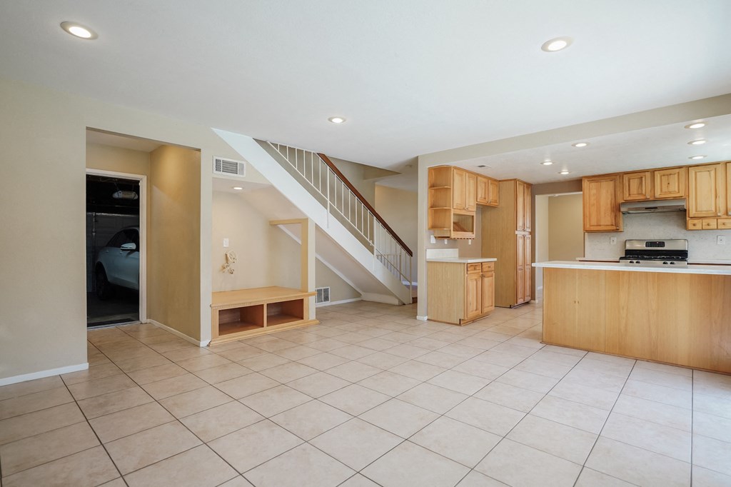 an open kitchen and living room with a staircase