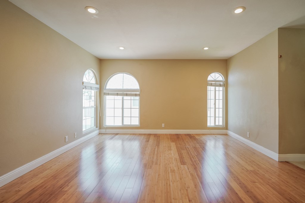 an empty living room with wood floors and windows