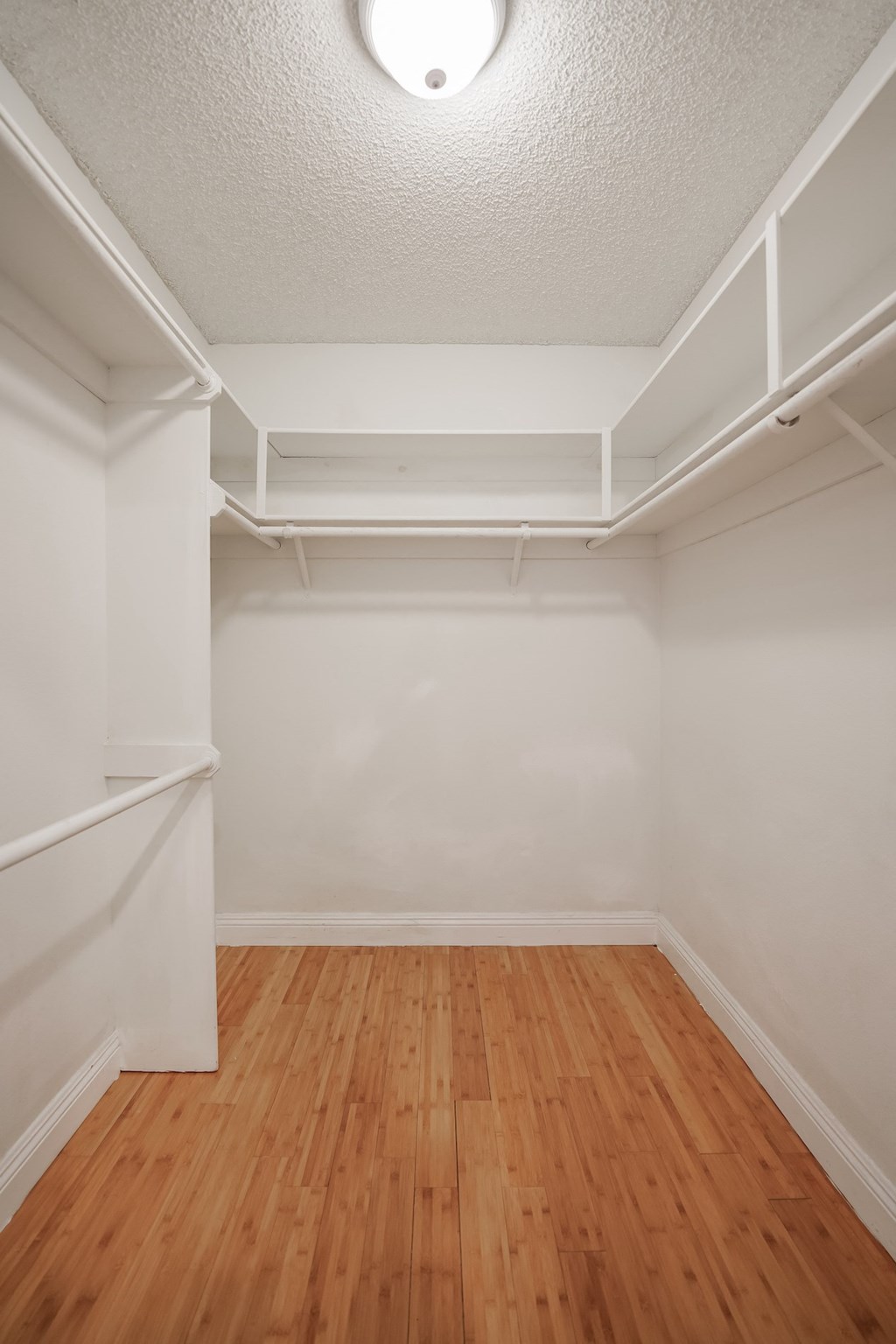 the living room of an empty house with wood floors and white walls