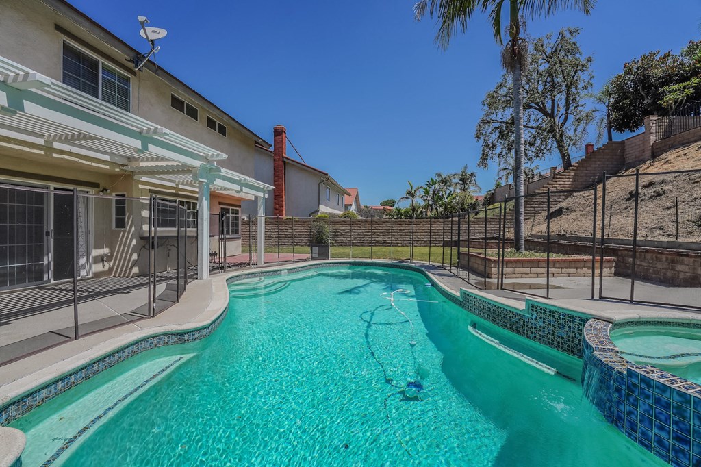a swimming pool with a house in the background