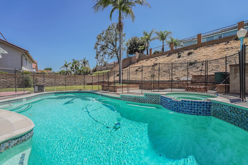 a swimming pool with a fence around it and a resort style pool