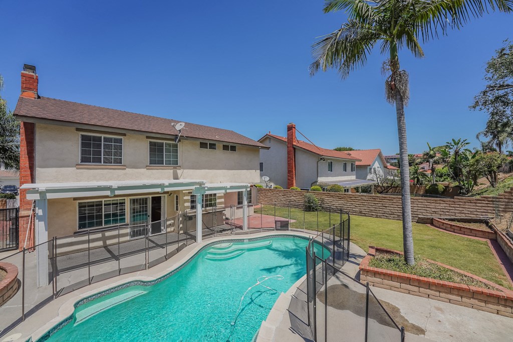 a house with a swimming pool and a house in the background