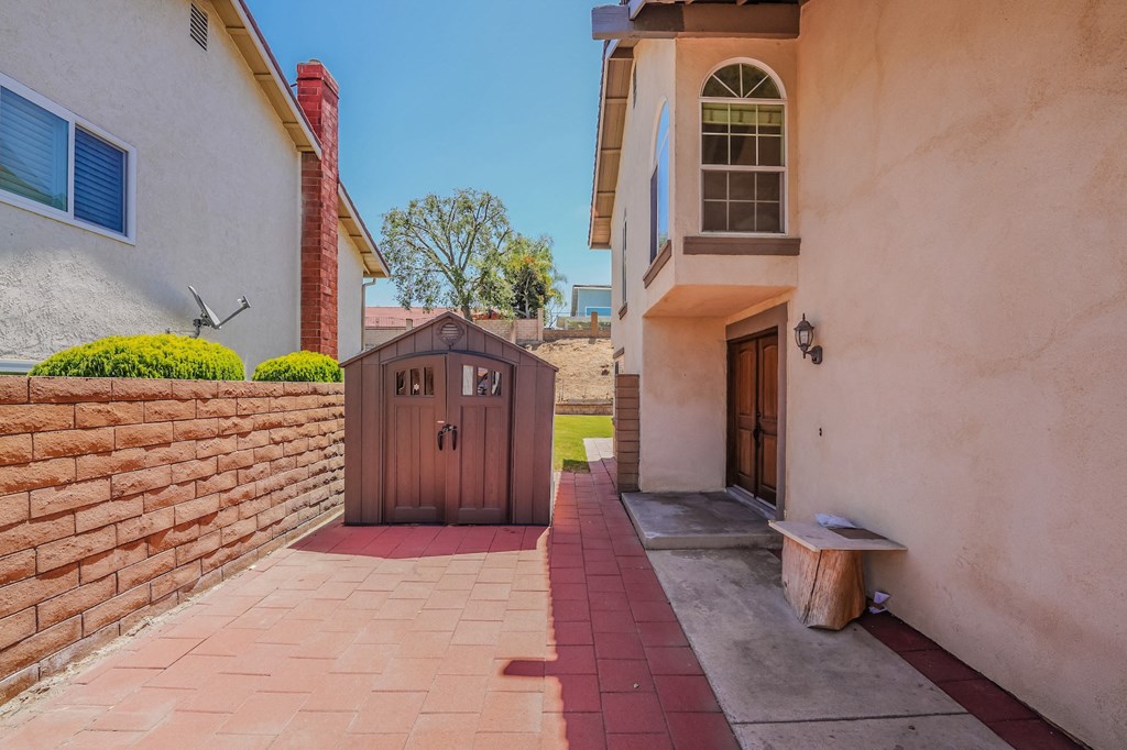 the front door of a house with a wooden gate and a brick wall