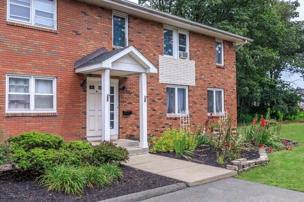 the front of a brick house with a white door