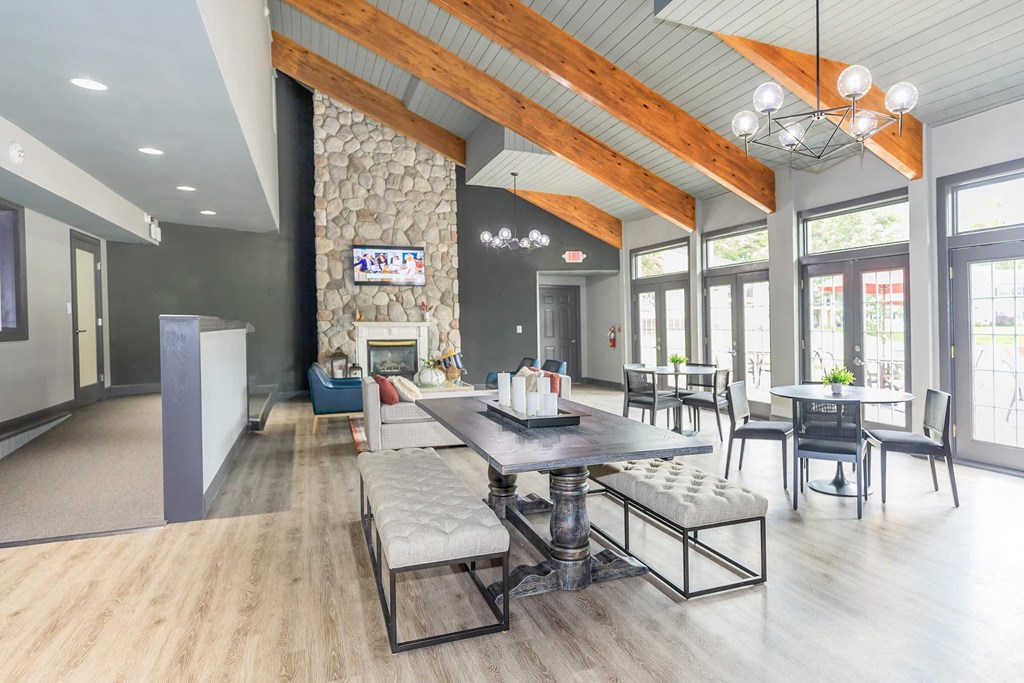 a clubhouse with a stone fireplace and tables and chairs