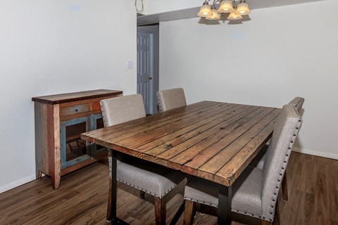 a dining room with a wooden table and chairs