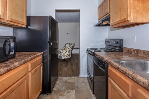 a kitchen with black appliances and wooden cabinets