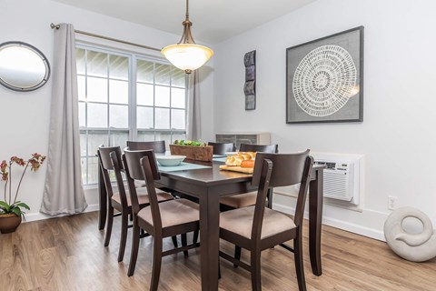 a dining room with a table and chairs and a window