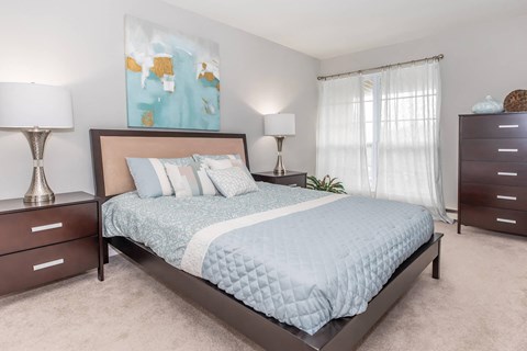a bedroom with a bed and two dressers
