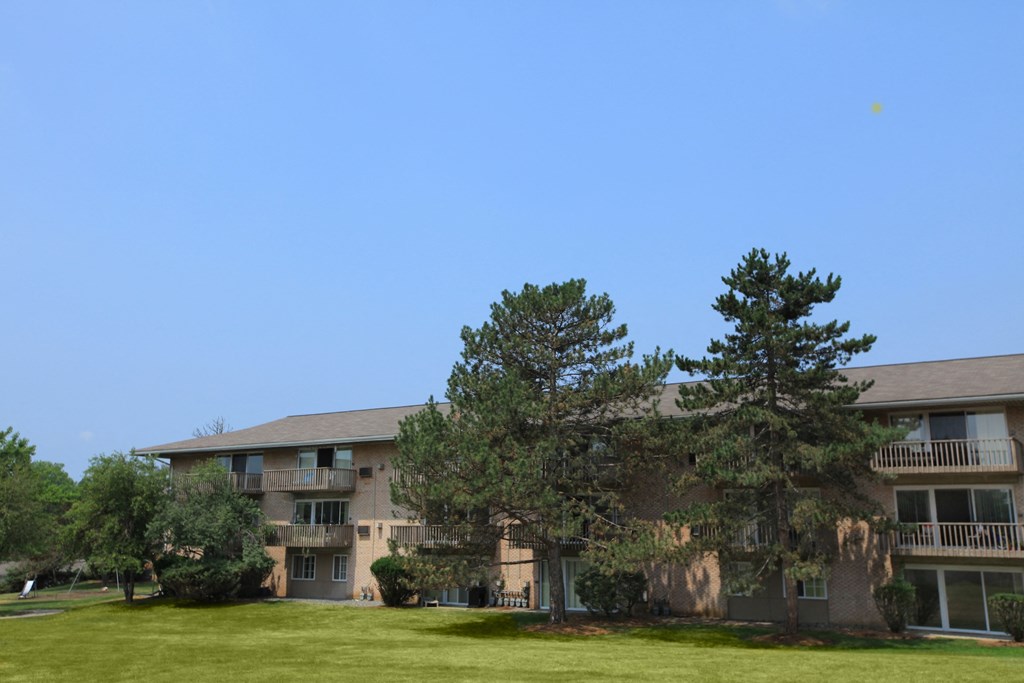the view of an apartment building with trees in front of it