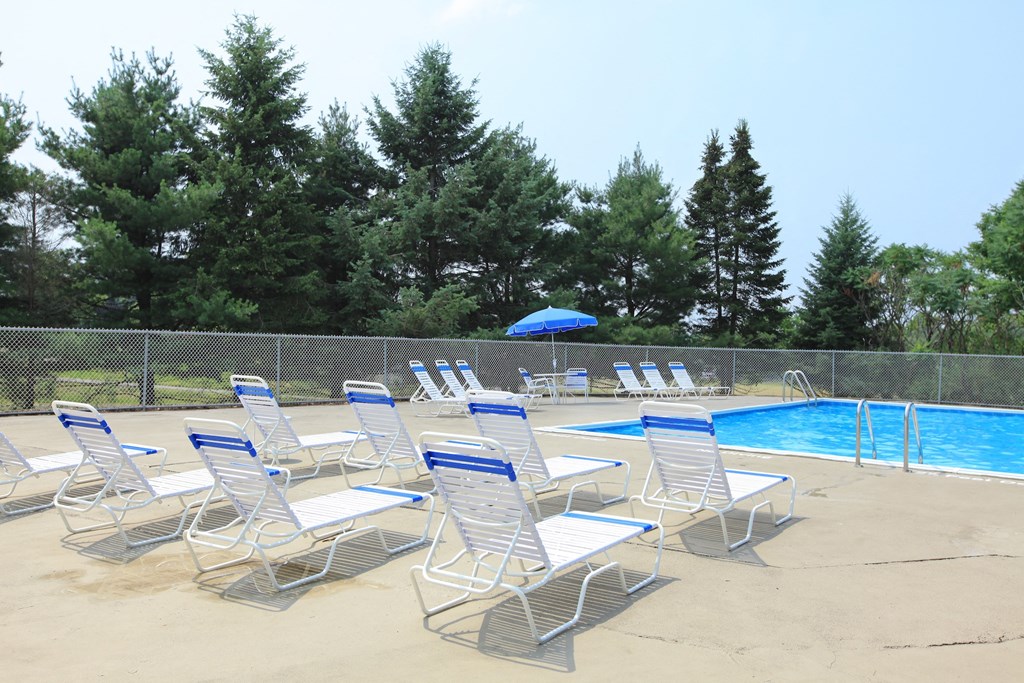 a group of lounge chairs next to a swimming pool