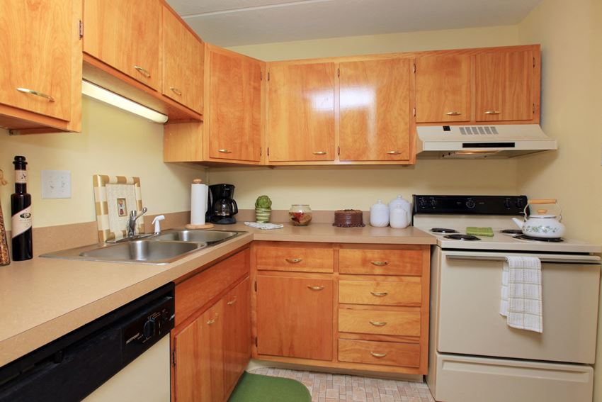 a kitchen with wooden cabinets and white appliances and a sink